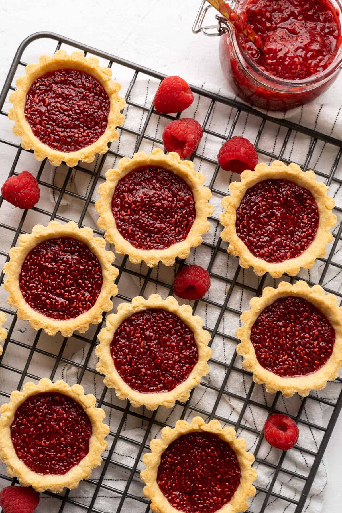 Raspberry jam tarts on a cooling rack.