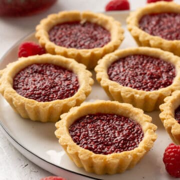 Some jam tarts on a plate view from front.