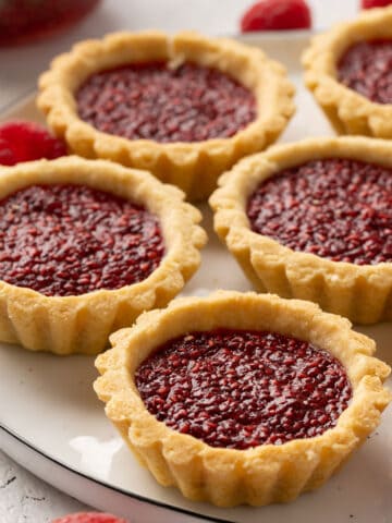 Some jam tarts on a plate view from front.