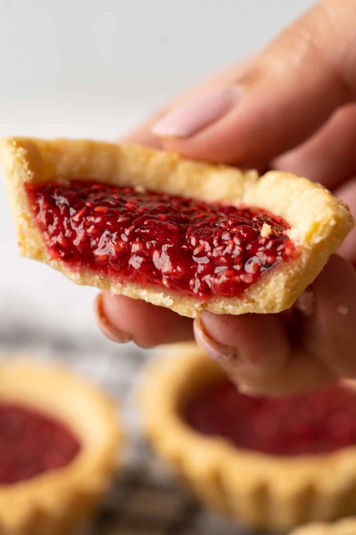 Showing the inside texture of one jam tart.