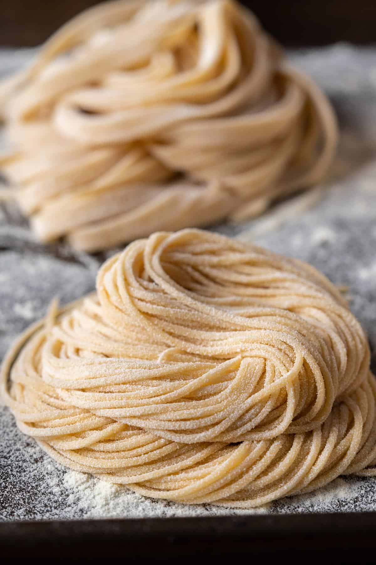 2 bundles of egg noodles on a tray.