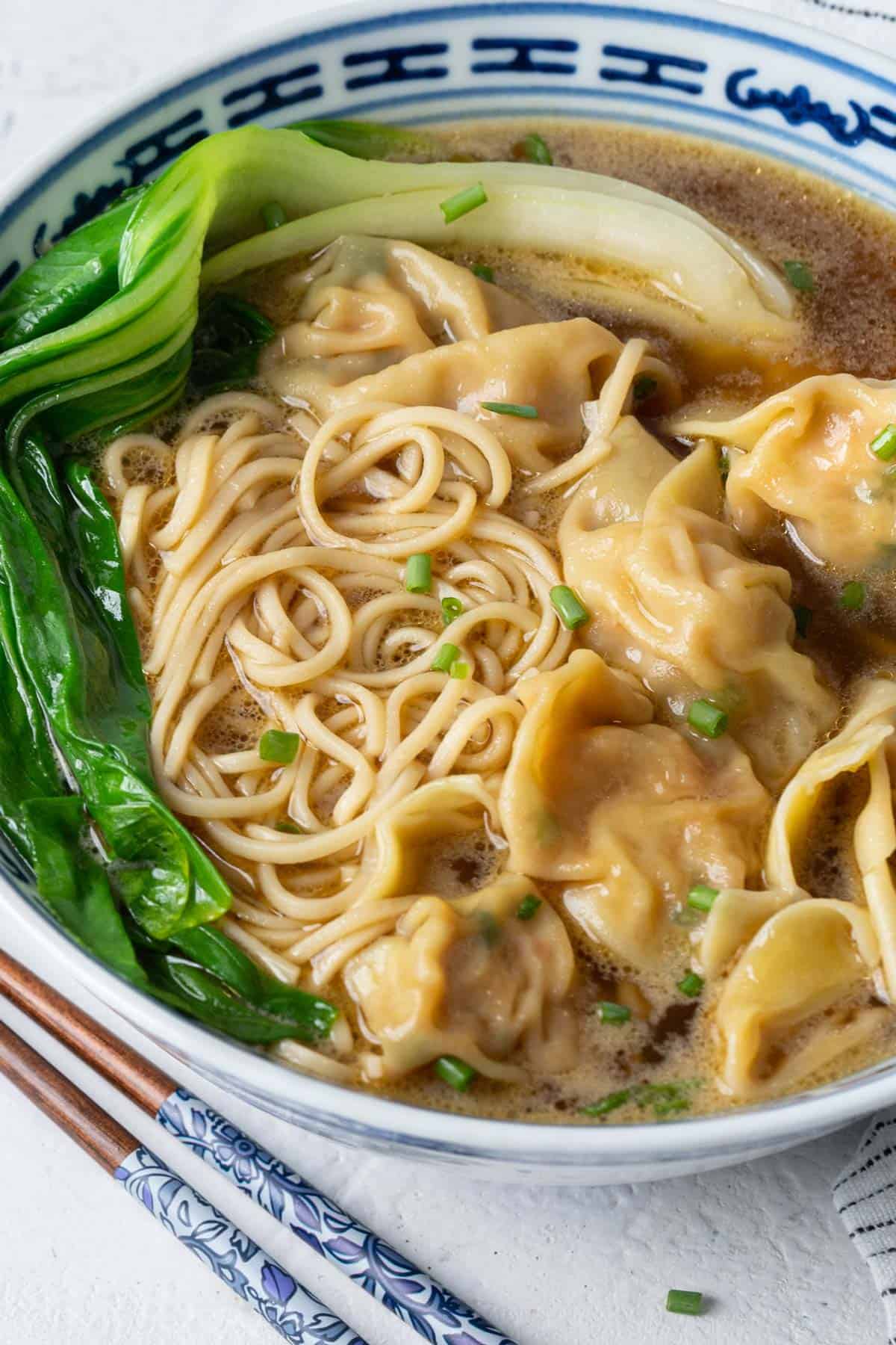 Wonton noodle soup in a bowl view from front.