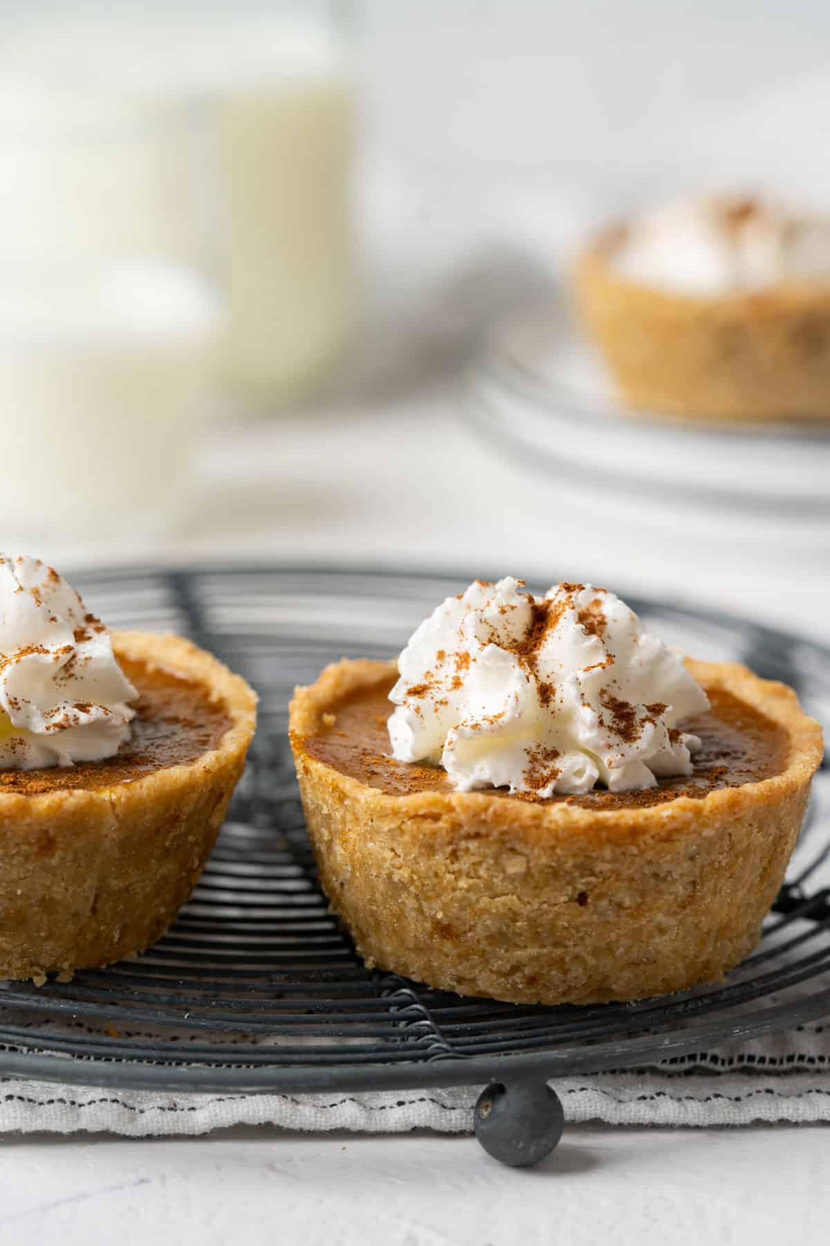 Mini pumpkin pies on a cooling rack close up.