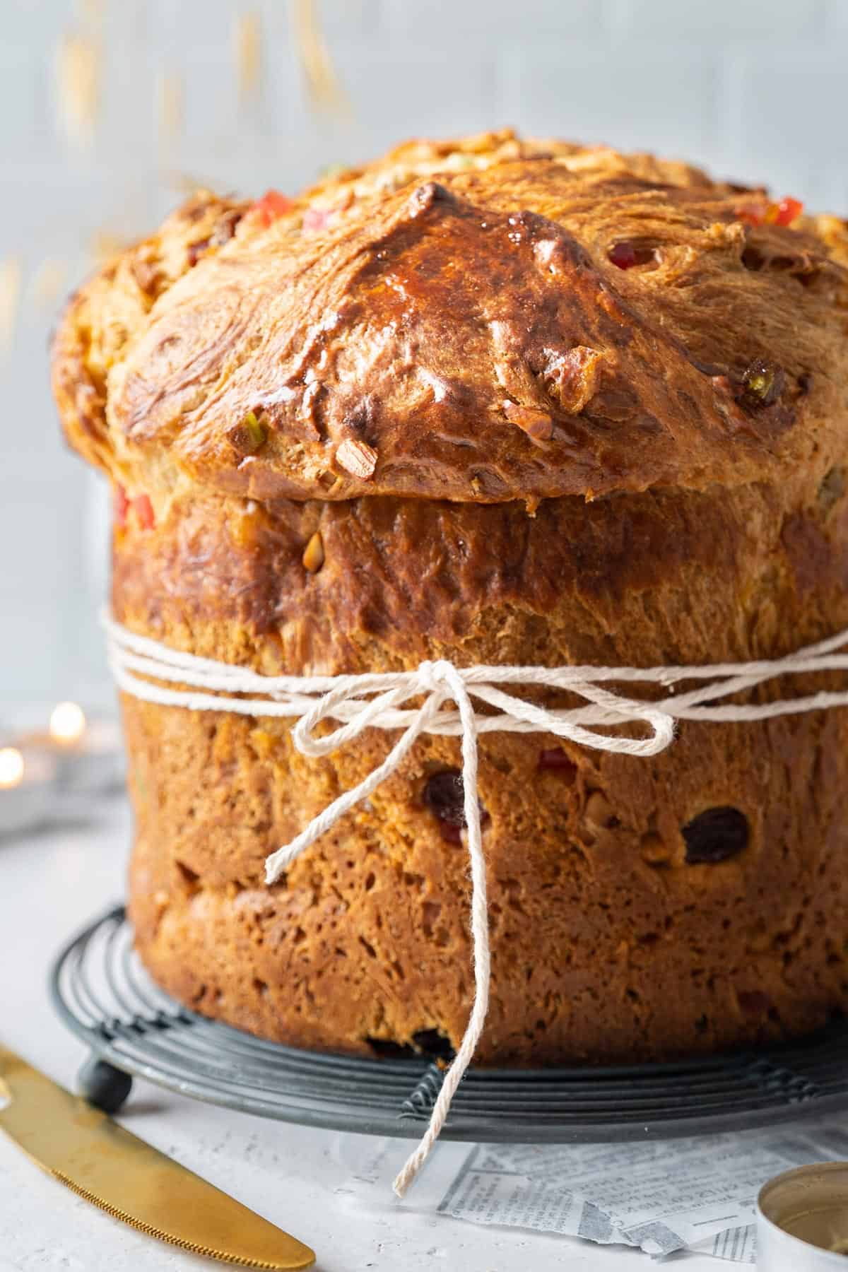 Panettone without its mould, on a cooling rack.