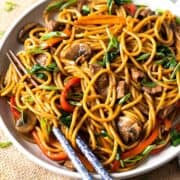 Lo mein noodles served in a plate with chopsticks.