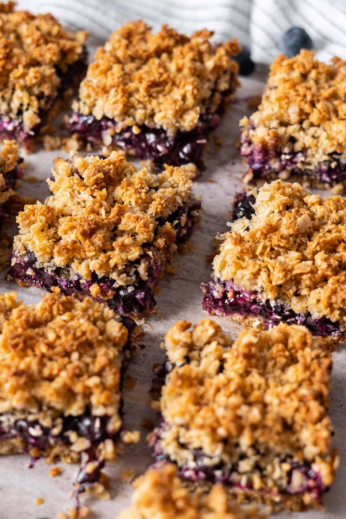 Sliced blueberry bars on parchment paper.