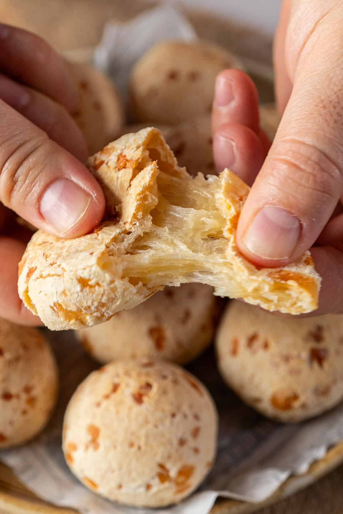 Tearing up one pao de queijo.