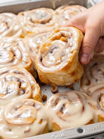 Taking out a piece of apple cinnamon rolls.