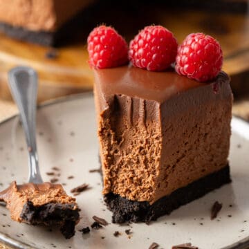 A slice of chocolate cheesecake that's half-eaten.