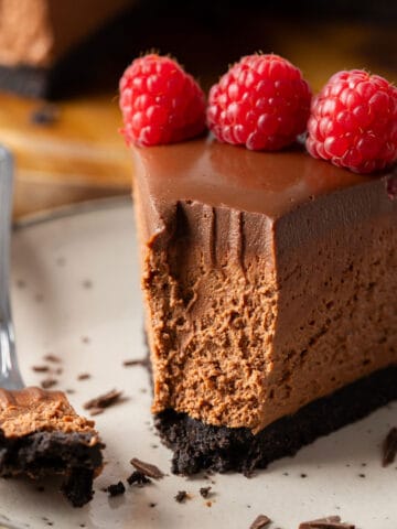 A slice of chocolate cheesecake that's half-eaten.