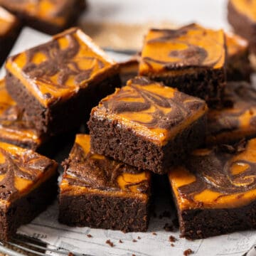 Delicious pumpkin cheesecake brownies on a plate.
