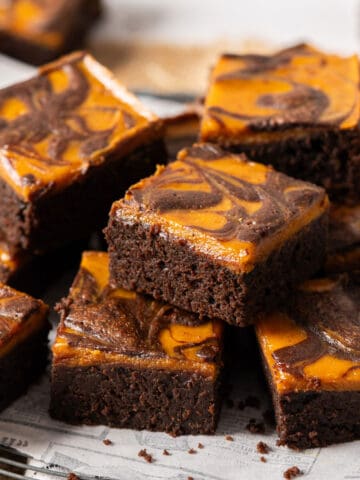 Delicious pumpkin cheesecake brownies on a plate.