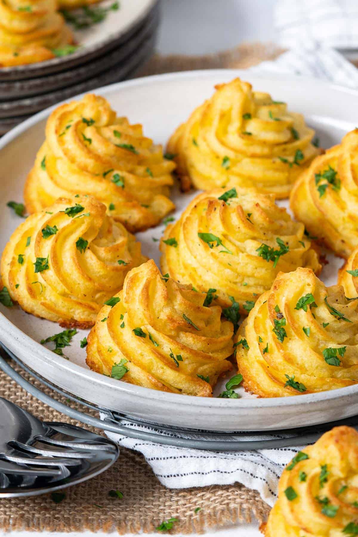 Parmesan Duchess potatoes served on a plate view from the front.