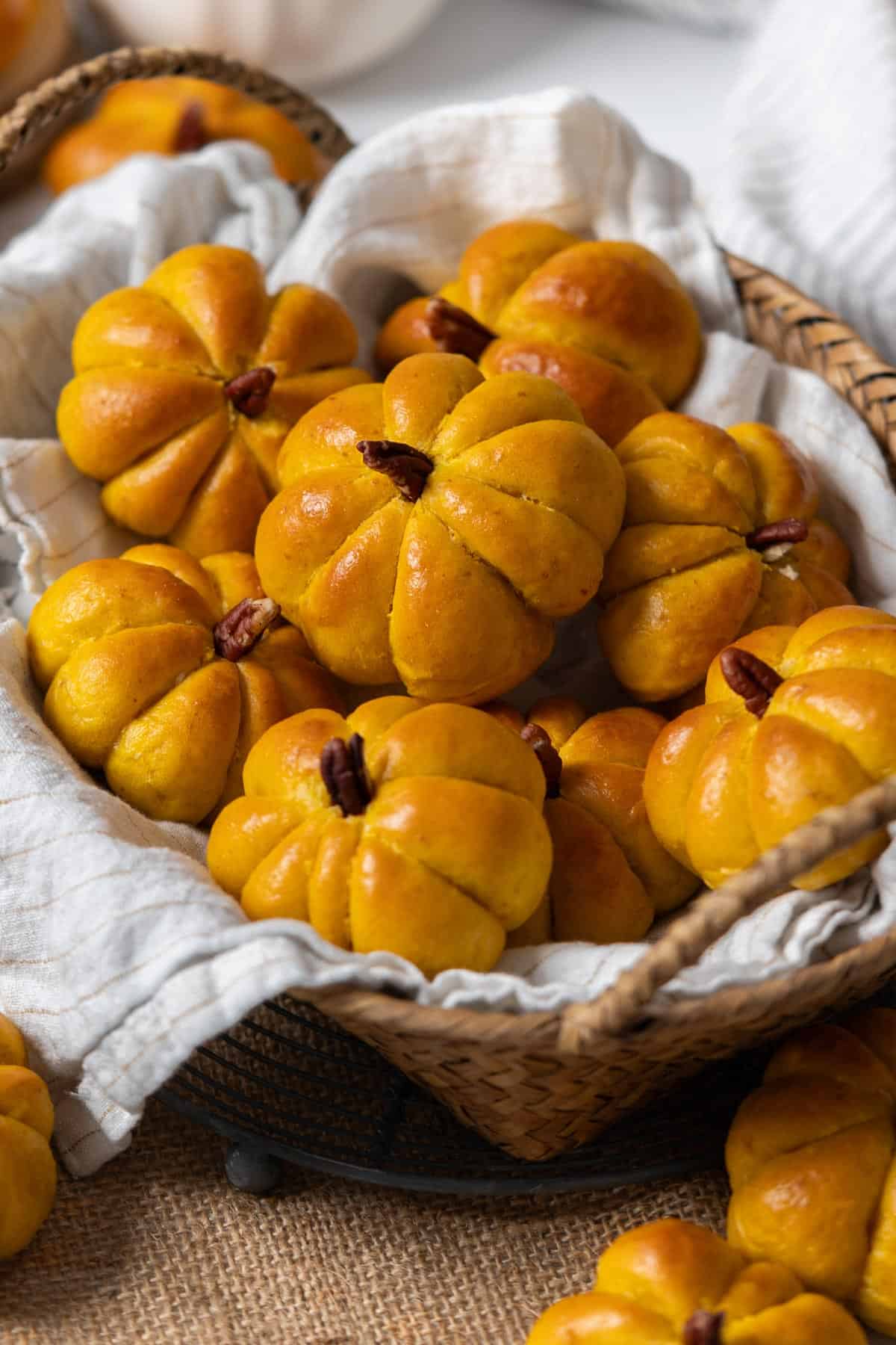 Pumpkin dinner rolls in a basket view from the front.