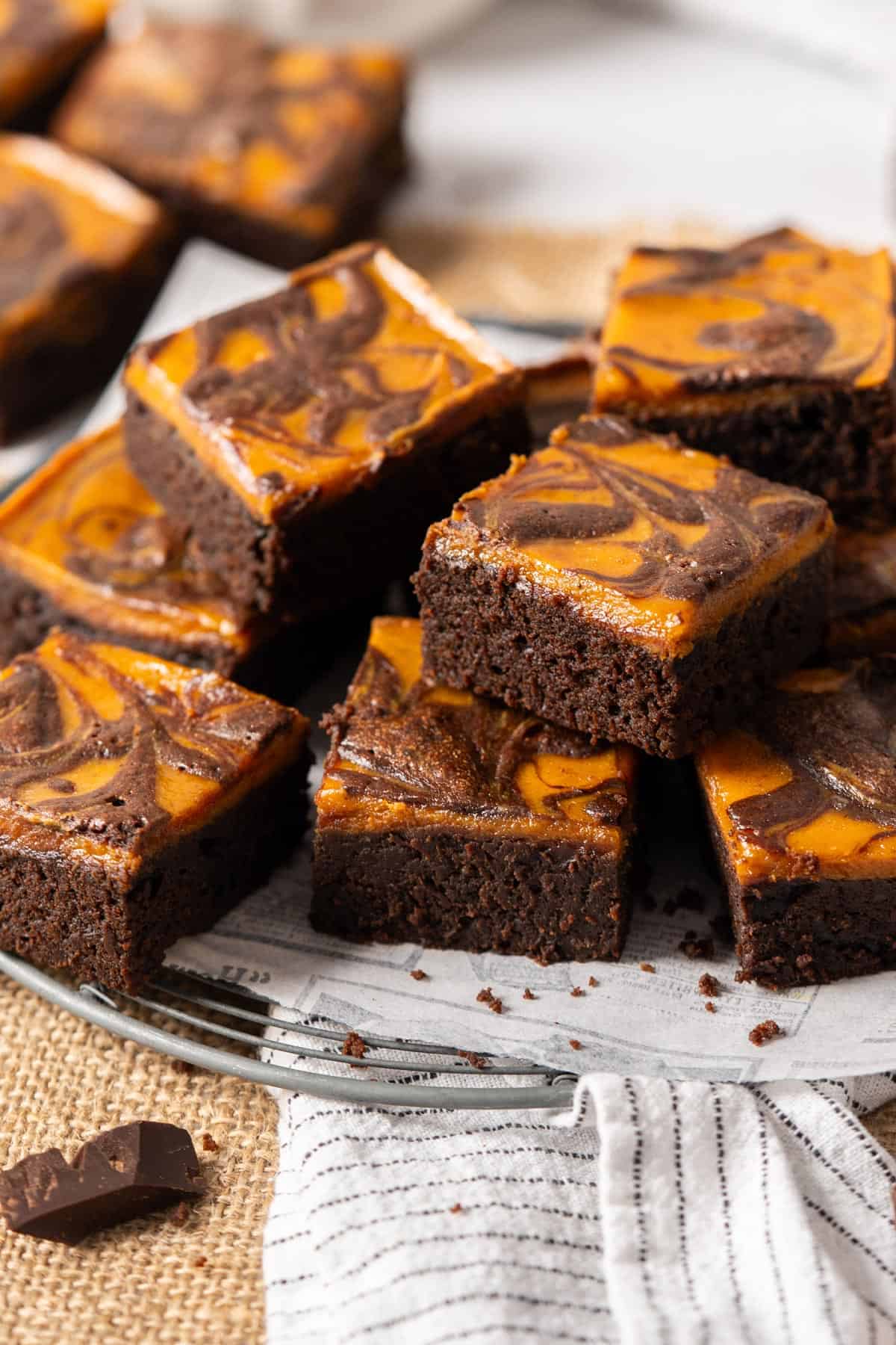 Sliced pumpkin cheesecake brownies on a cooling rack.