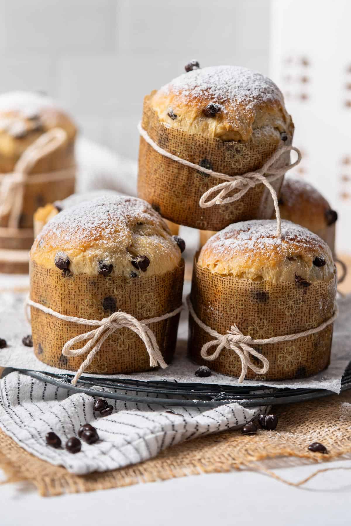 Stacked mini panettone with chocolate chips on a cooling rack.