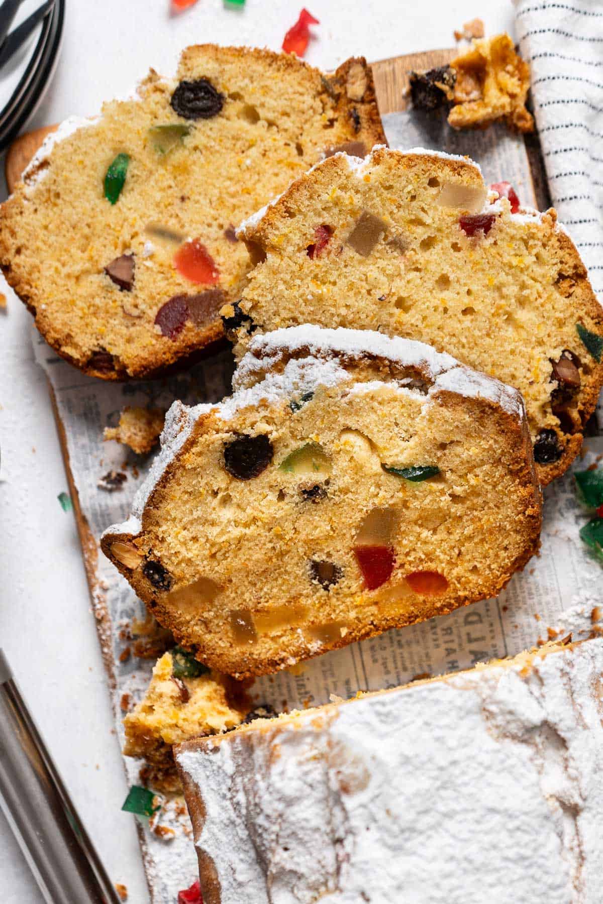 Three slices of fruitcake on a wooden table.