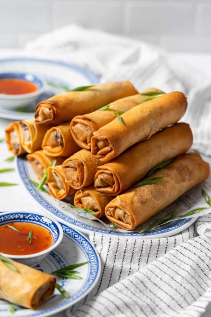 A stack of crispy spring rolls on a plate.