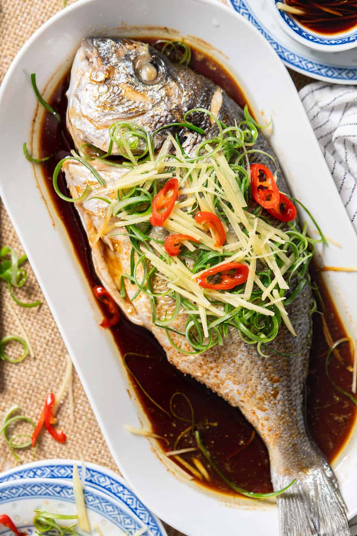 Chinese steamed whole fish on a serving plate.