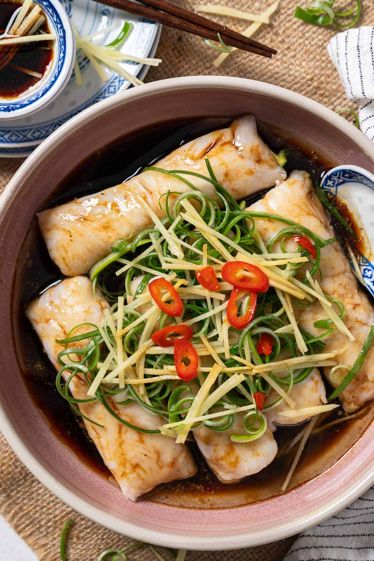 Ginger steamed fish fillets on a serving plate.