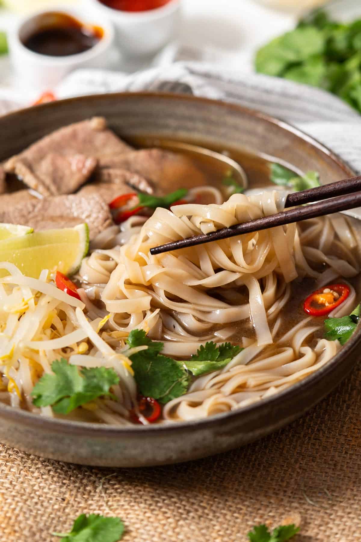 Grabbing the noodles of quick pho with chopsticks.