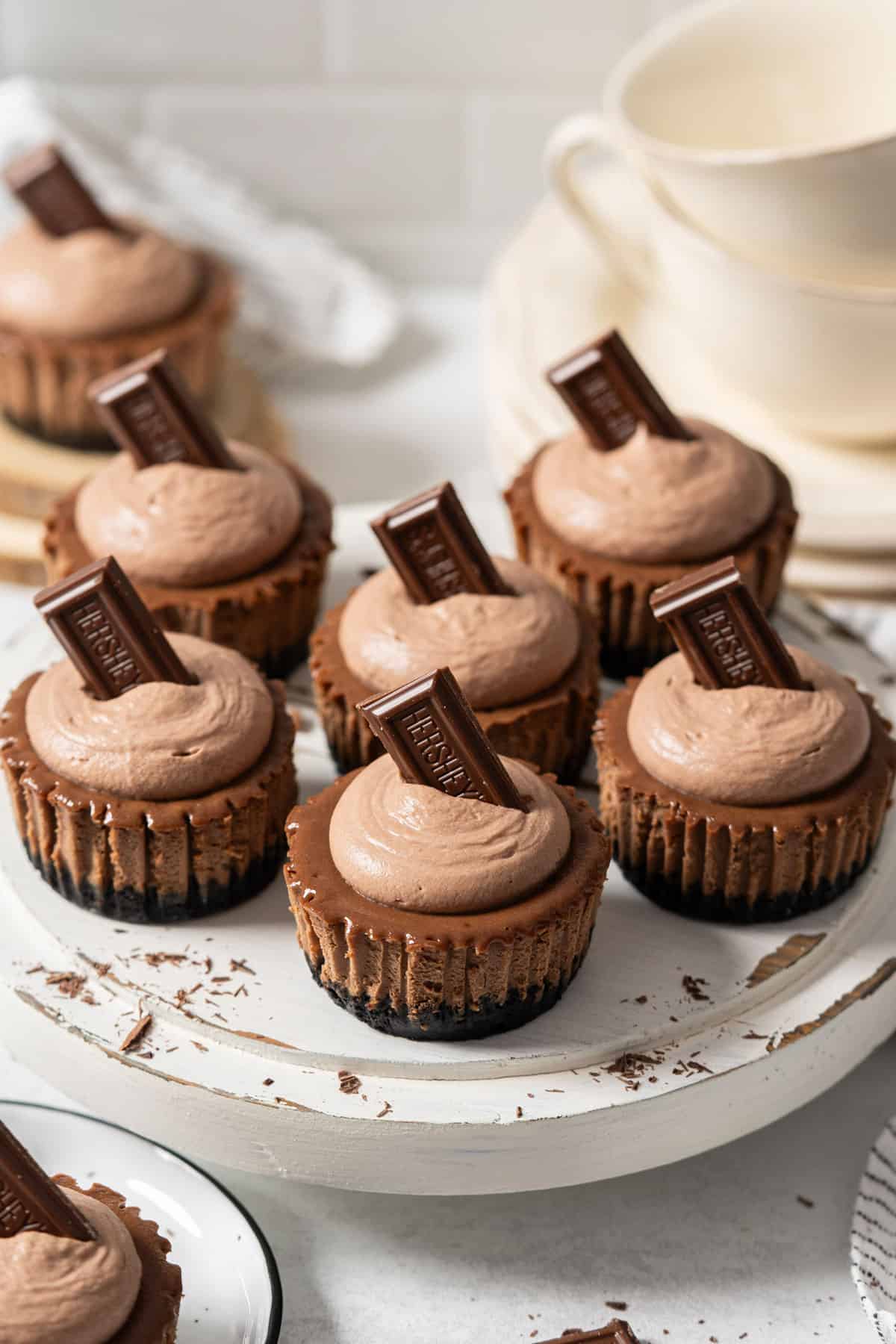 Mini chocolate cheesecakes on a cake stand.