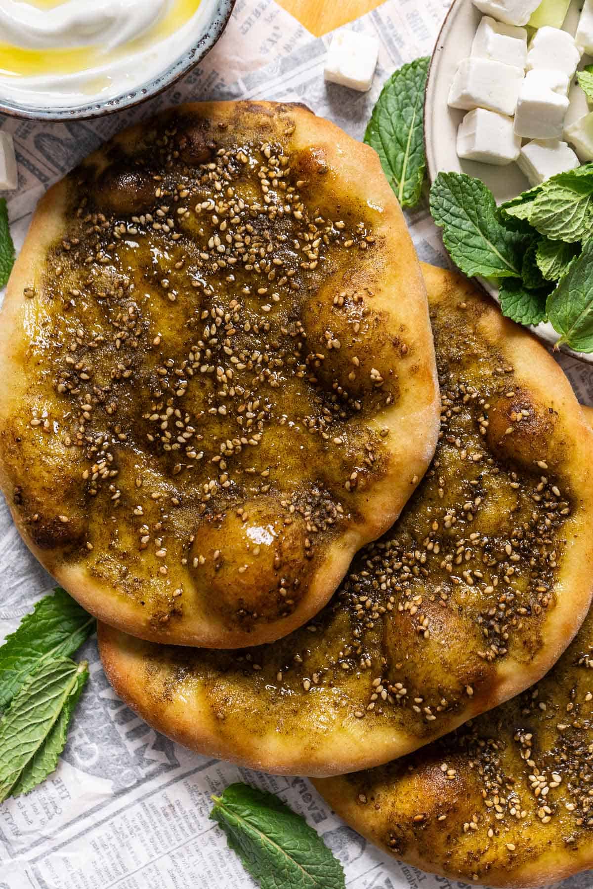 Stacked Lebanese flatbreads on a pizza peel.