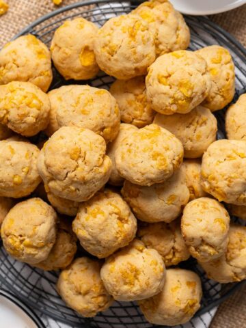 Cornflake cookies stacked on a cooling rack.