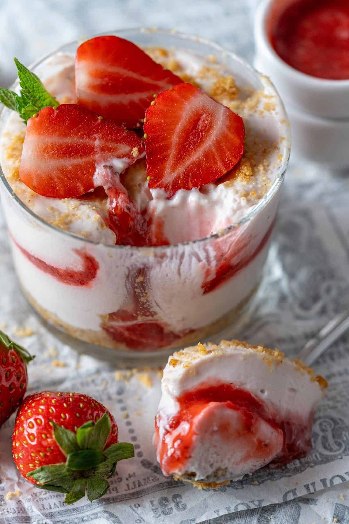 A spoonful of high-protein cheesecake with the glass in the background.
