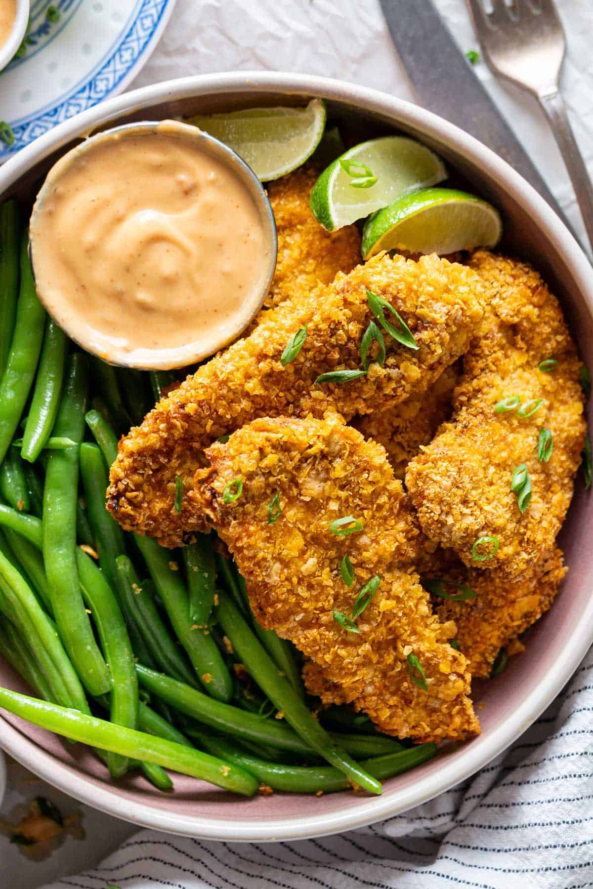 Air fryer bang bang chicken served with steamed beans and sauce.