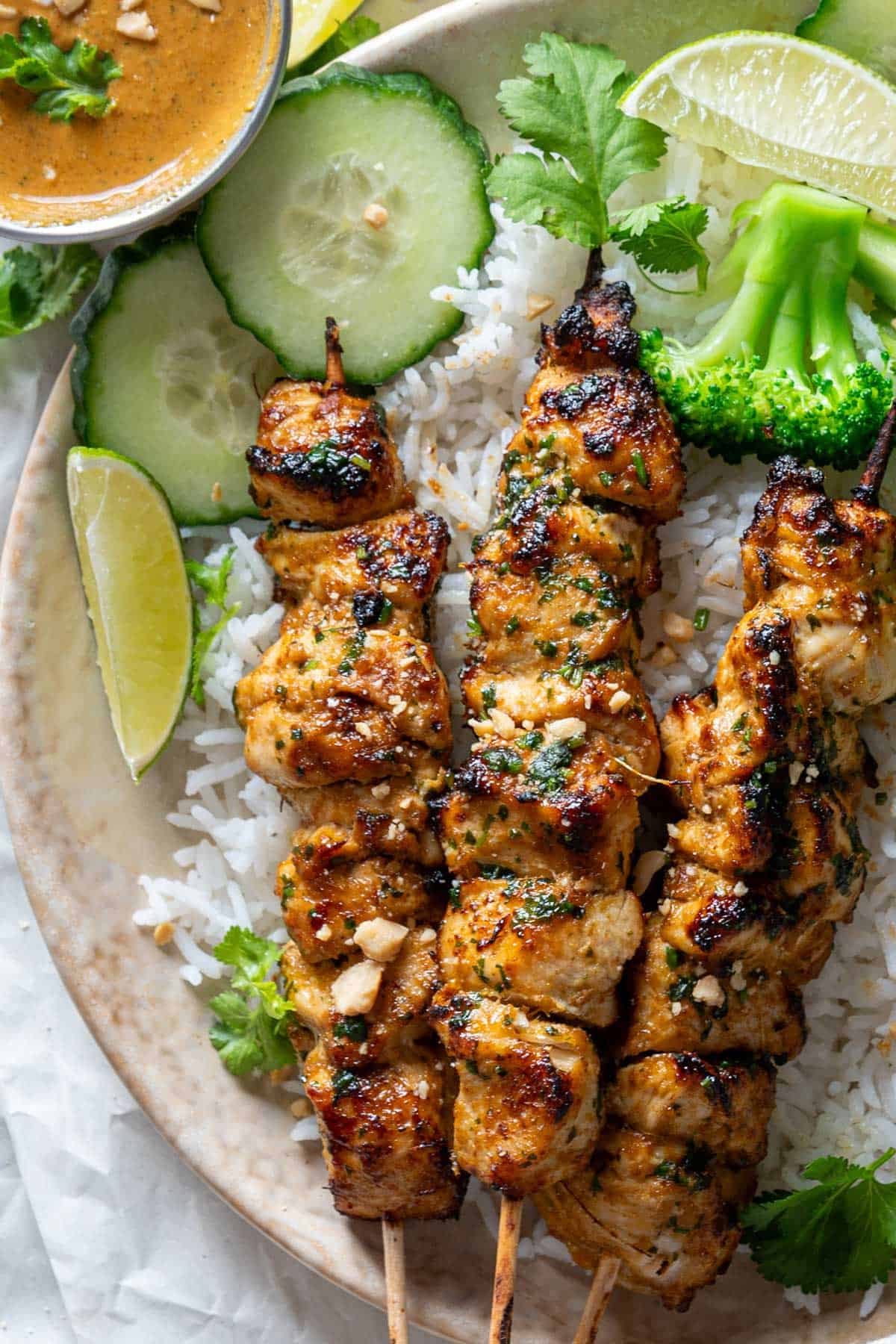 Chicken skewers with peanut sauce served with rice.