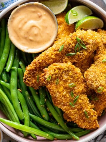 Air fryer bang bang chicken with green beans, view from top.