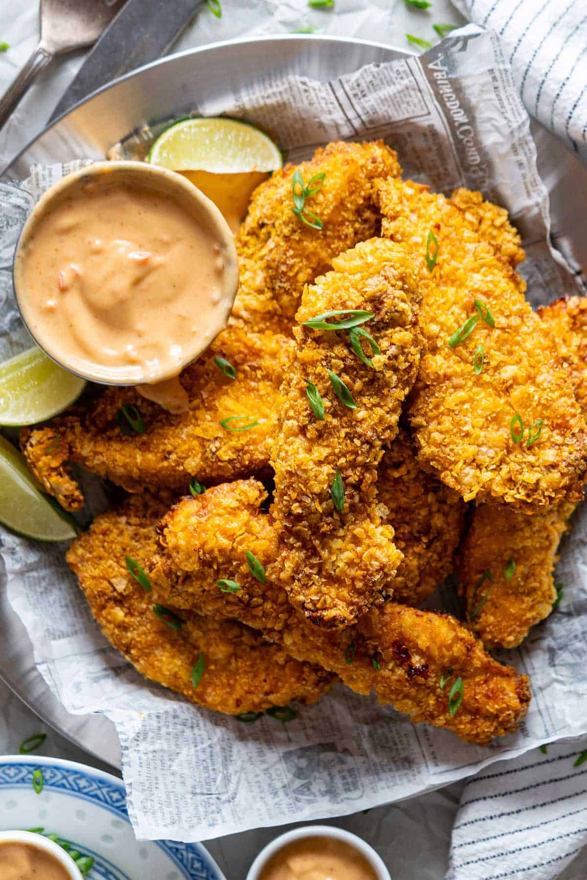 Pieces of air fryer bang bang chicken on a plate with the sauce.