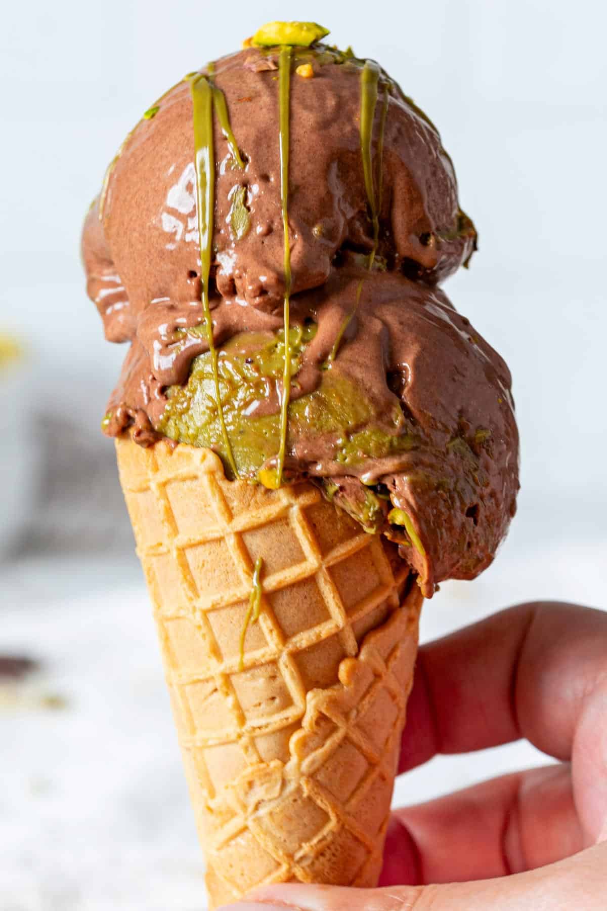 Pistachio chocolate ice cream in a cone.