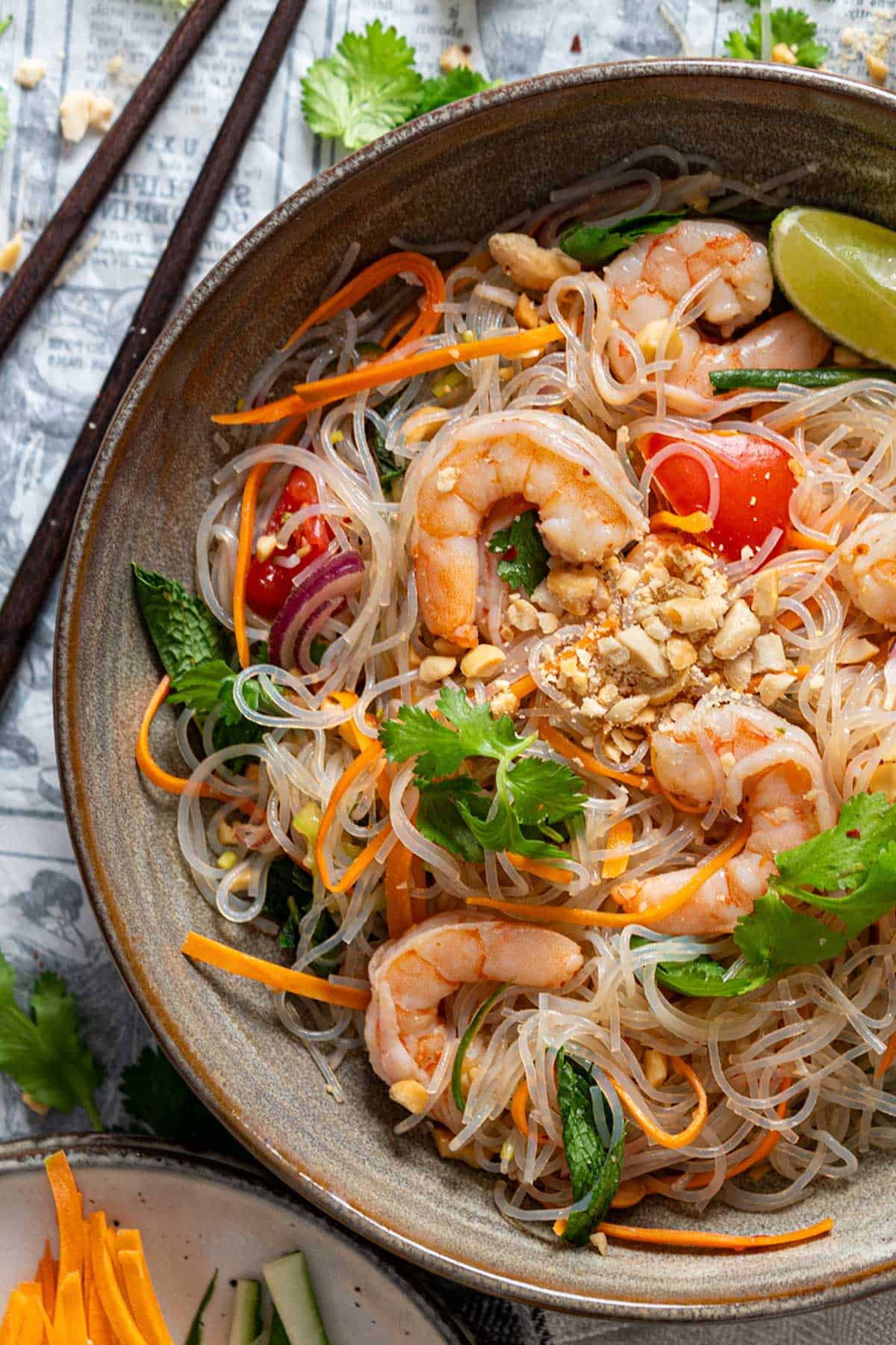 Thai glass noodle salad with shrimp in a bowl view from top.