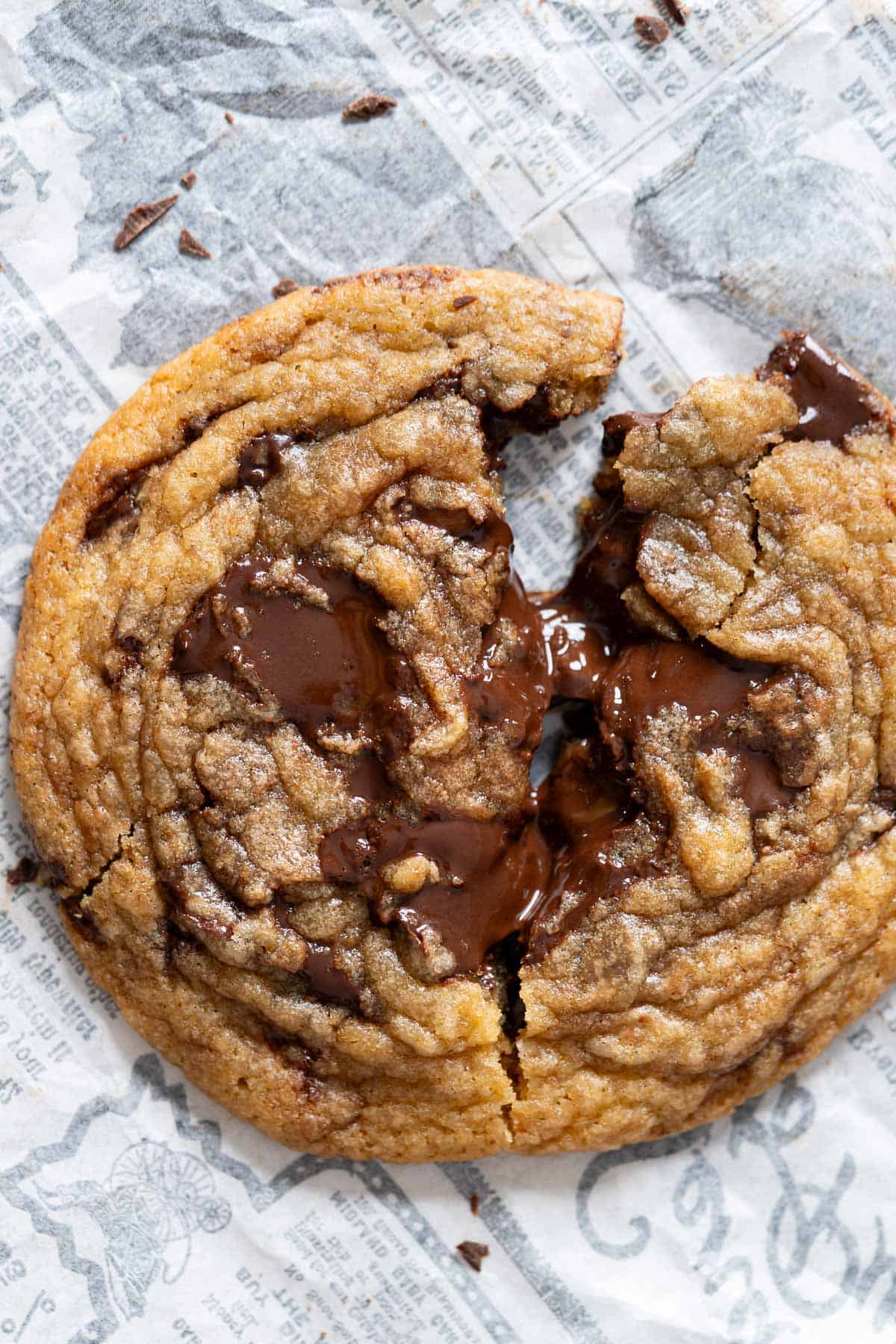 A single chewy chocolate chunk cookie broken in half.