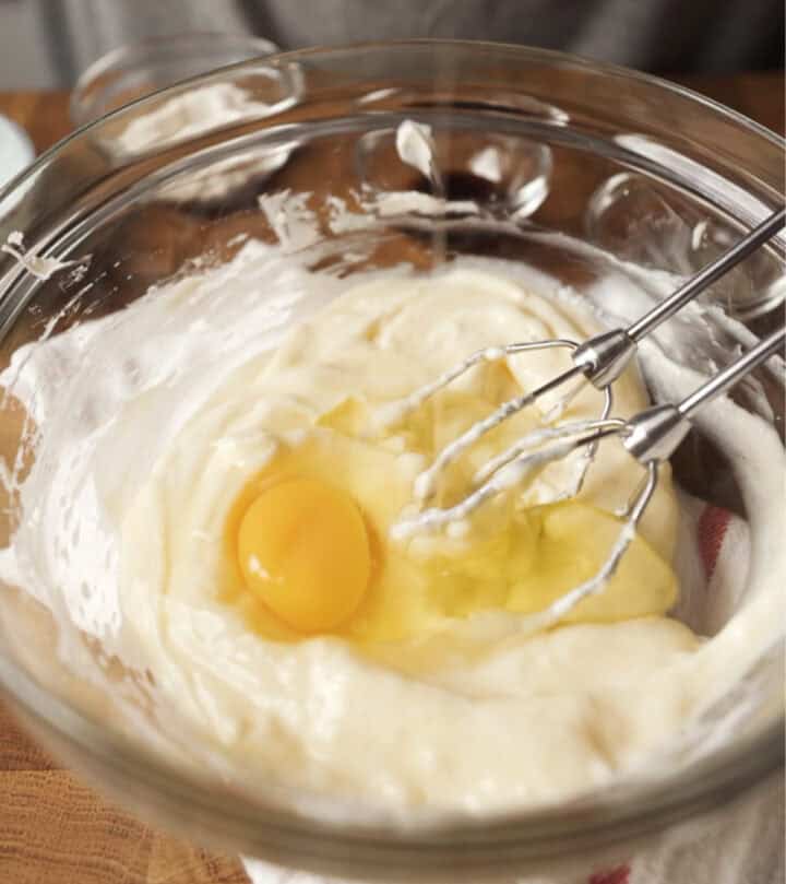 Adding the eggs to the cream.