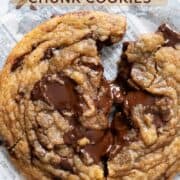 Close up of one chewy chocolate chunk cookie broken in half.