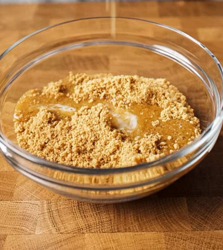Mixing the cookie crumbs with butter.
