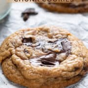 One chewy chocolate chunk cookie on a parchment paper.