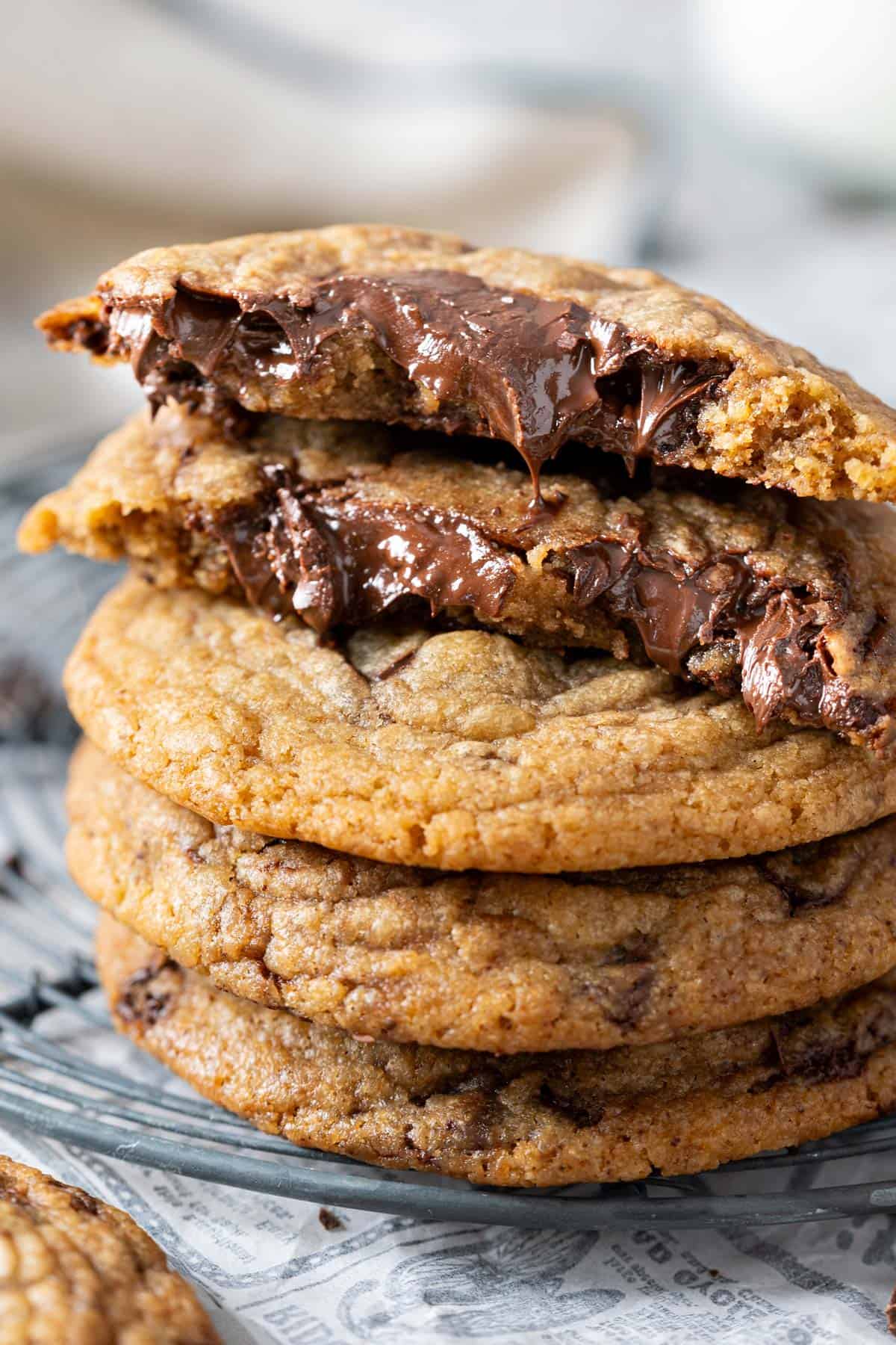 Stacked chewy chocolate chunk cookies on a cooling rack.