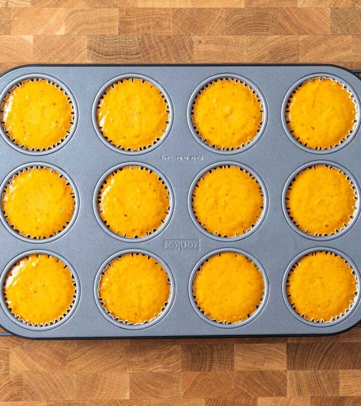 Baked mini pumpkin cheesecakes in a muffin pan.