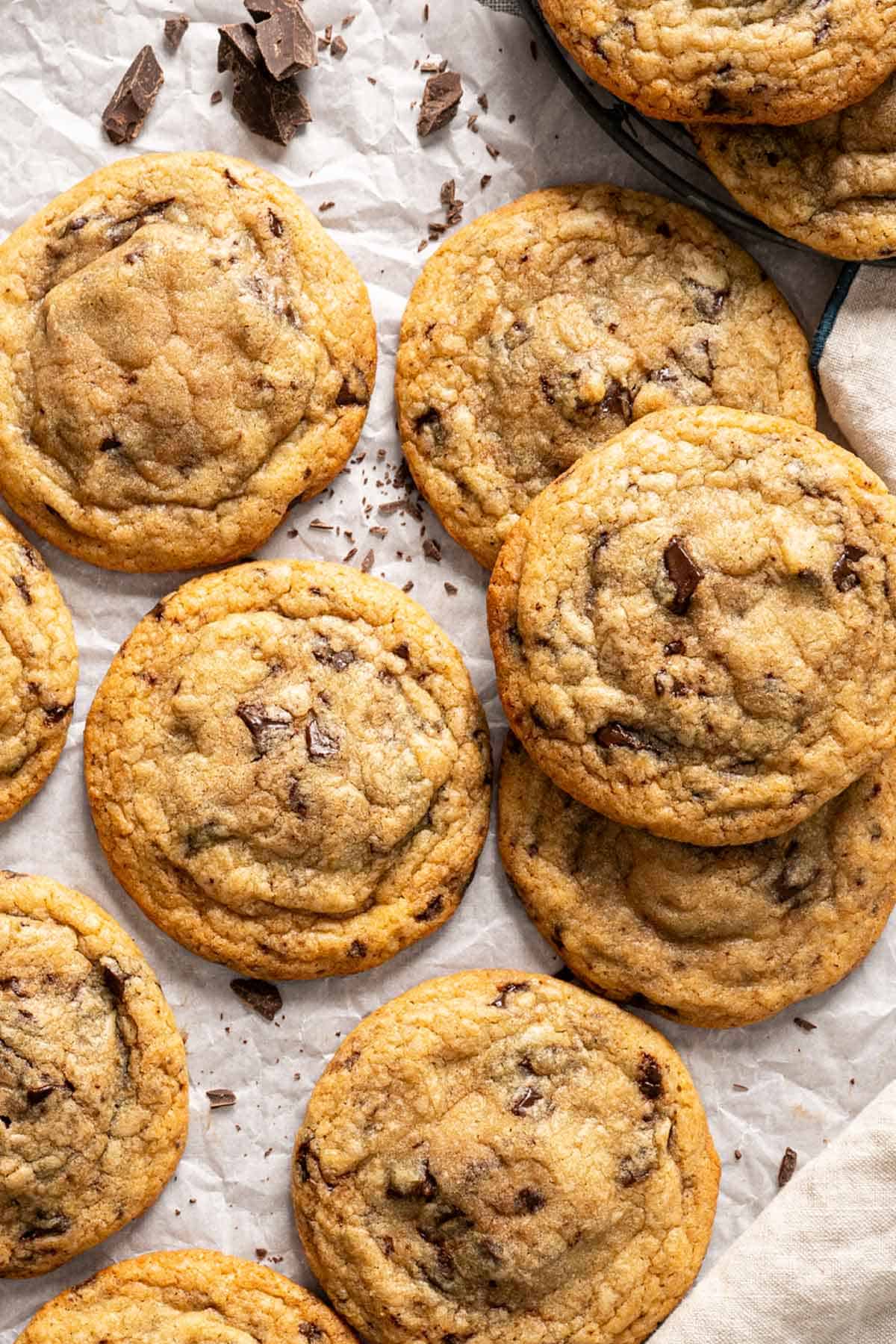 Batch of Nutella-stuffed cookies with chocolate chunks on parchment paper.