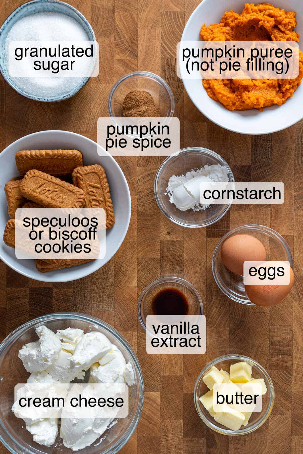 Ingredients for mini pumpkin cheesecake recipe with cream cheese, pumpkin puree, and Biscoff cookies.