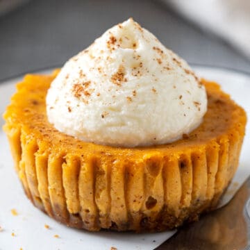 Mini pumpkin cheesecake with Biscoff crust and whipped cream topping.