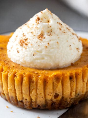Mini pumpkin cheesecake with Biscoff crust and whipped cream topping.