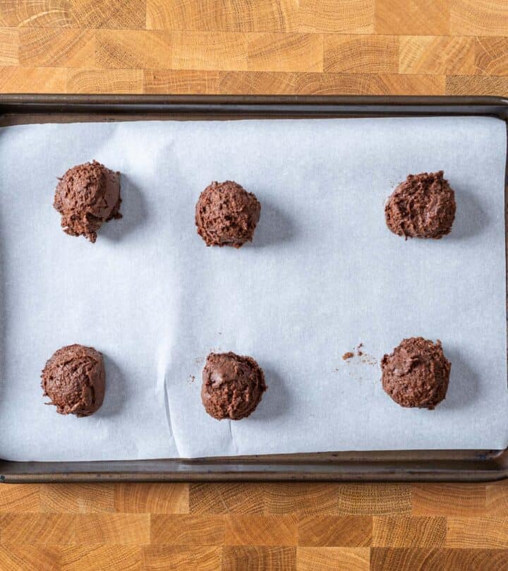 Scooped dough on a lined tray.