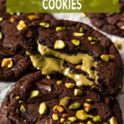 Chocolate pistachio cookie broken open with gooey pistachio cream filling and fudgy brownie-style texture.