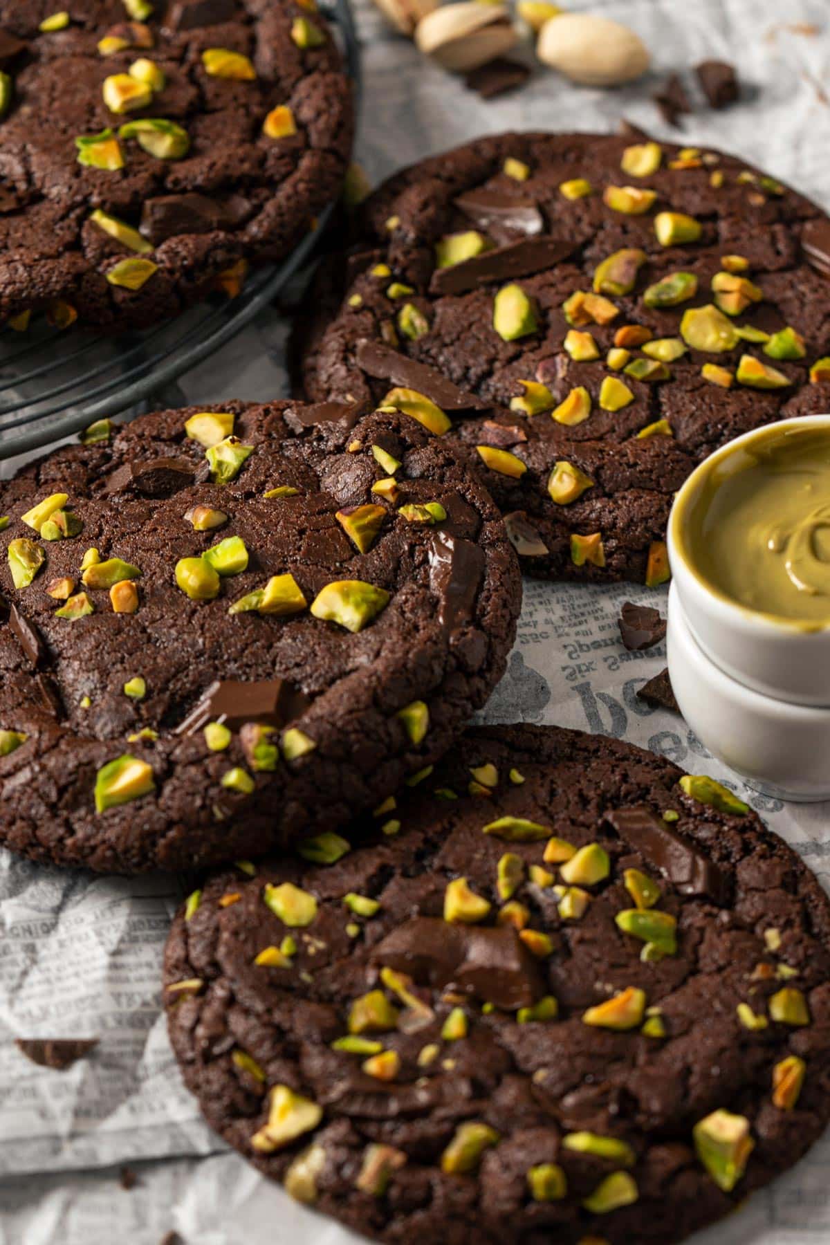 Chocolate pistachio cookies on a parchment paper view from front.