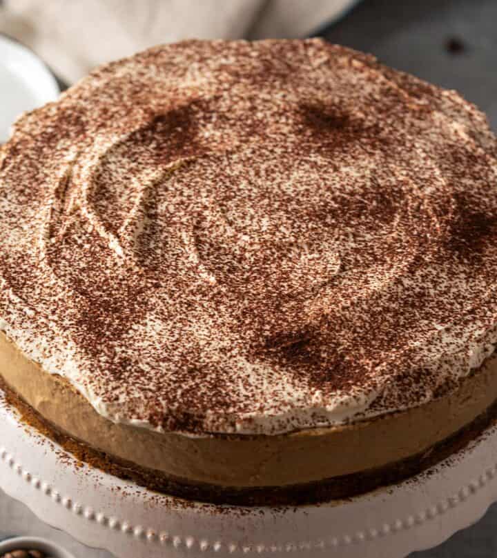 Dusting coffee cheesecake with cocoa.